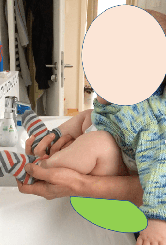 Ein Baby wird in die klassische Abhalteposition gebracht, Bild: (c) Liane Emmersberger